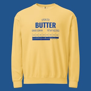 Puede incluir: Una sudadera amarilla con la palabra "BUTTER" en letras azules. El texto "UNSALTED" y "GRADE USDA AA" están encima de la palabra "BUTTER". El texto "NET WT 4OZ (113g)" está a la derecha de la palabra "BUTTER". Debajo, un gráfico azul con medidas.