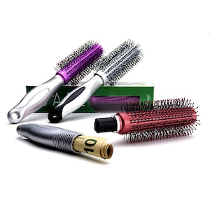 Könnte beinhalten: Drei Haarbürsten mit versteckten Fächern. Die Bürsten sind silber, lila und rot. Die silberne Bürste hat einen Zehn-Euro-Schein drin.