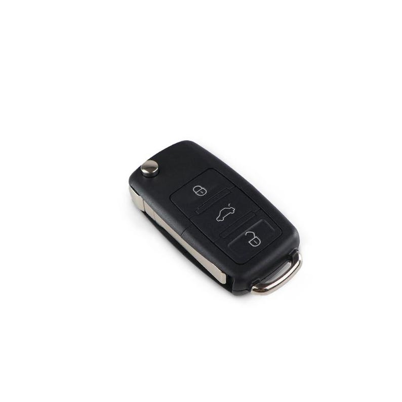 May include: A black car key with silver accents. The key has three buttons with icons for locking, unlocking, and opening the trunk. A small metal loop is attached for a key ring.