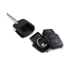May include: A black car key with a silver key blade and a separate key fob. The key fob has buttons for locking, unlocking, and opening the trunk. The key is disassembled, showing the internal components.