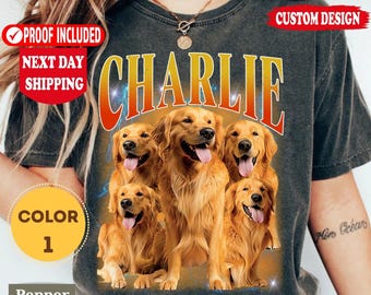 Puede incluir: Una camiseta gris carbón con un gráfico de cuatro perros golden retriever con la lengua fuera. La palabra CHARLIE está impresa en letras grandes y negritas con un degradado de naranja a amarillo sobre los perros. La camiseta tiene un aspecto vintage.
