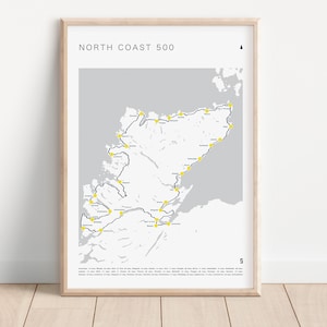 May include: A framed map of the North Coast 500 route in Scotland. The map is printed on a light grey background with a dark blue route line and yellow dots marking points of interest.