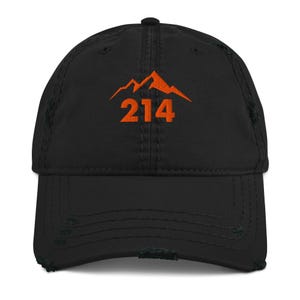 May include: A black distressed baseball cap featuring an embroidered orange mountain graphic above the number 214. The hat has a structured crown, a curved brim with frayed edges, and matching black stitching throughout the fabric panels.