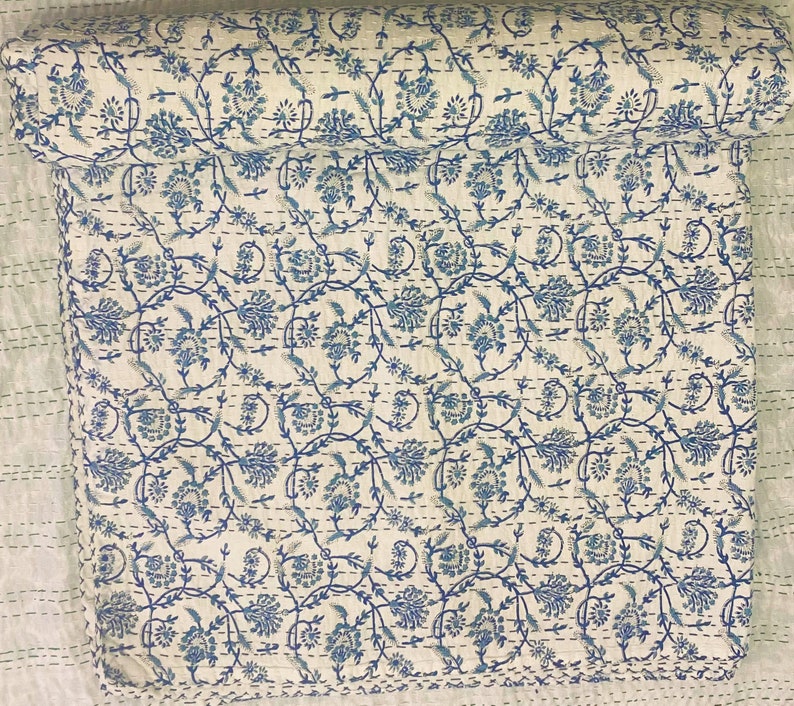 Pode incluir: Uma colcha kantha de algod&atilde;o branco com um padr&atilde;o floral azul. A colcha &eacute; costurada &agrave; m&atilde;o e tem um design tradicional indiano.