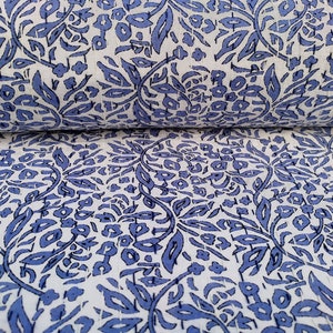 May include: White fabric with a blue floral pattern. The fabric is folded in half, showing the pattern on both sides.