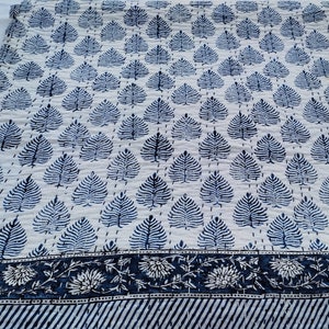 Puede incluir: Una colcha de algod&oacute;n blanco con un patr&oacute;n de hojas azules y un borde azul y blanco. La colcha est&aacute; cosida a mano y tiene un dise&ntilde;o tradicional indio.