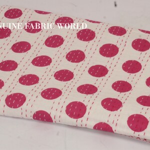 May include: White fabric with a pink polka dot pattern. The fabric is folded in half and the text "GENUINE FABRIC WORLD" is visible in the top left corner.