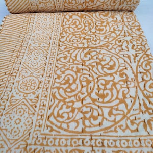 May include: A white cotton kantha quilt with a brown floral pattern. The quilt is hand-stitched and has a traditional Indian design.