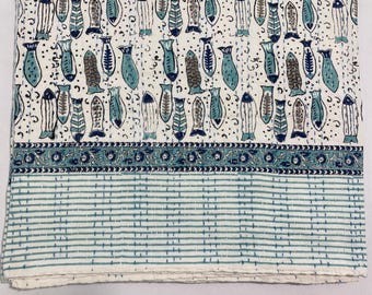 May include: White cotton fabric with a blue and gray fish print. The fabric has a blue and white border with a floral design. The fabric has a white and blue striped border.