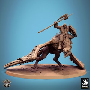 May include: A miniature figurine of an Orc riding a winged beast, holding a spear and shield. The figurine is painted in a brown color and is set on a circular base.