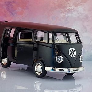 May include: A matte black Volkswagen bus model with a white VW logo on the front, silver bumpers, and open side doors. The front number plate displays the name JASON in black text. The interior features light-coloured seating visible through the windows.