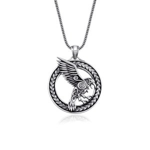 May include: Silver pendant necklace featuring a detailed raven design with Celtic knotwork. The raven is depicted in flight within a circular frame.