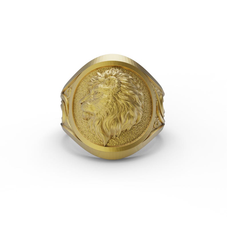 Puede incluir: Un anillo de oro con un dise&ntilde;o de cabeza de le&oacute;n detallado en el centro. El anillo tiene forma ovalada y una superficie texturizada.