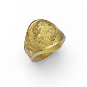 Puede incluir: Un anillo de oro con un dise&ntilde;o detallado de cabeza de lobo. El anillo tiene una superficie texturizada y una banda curva.