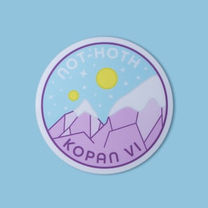 May include: Round sticker with a light blue background featuring a purple and white mountain range, two yellow suns, and the text "NOT-HOTH" and "KOPAN VI". The sticker has a purple border and the word "MATTE" in a yellow rectangle.