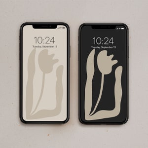 May include: Two black smartphones with a white background. Both phones display the time 10:24 and the date Tuesday, September 13. The phone on the left has a beige background with a stylised beige tulip graphic. The phone on the right has a black background with the same beige tulip graphic.