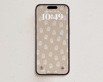 May include: A smartphone displaying a lock screen with a beige background featuring a repeating pattern of small, simple white ghost illustrations. The screen shows the date Monday, July 29 and the time 10:49 in a large white font with status icons.