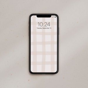 Puede incluir: Un teléfono inteligente negro con un patrón de cuadros blancos y rosa claro en la pantalla. La hora es 10:24 y la fecha es martes 13 de septiembre.