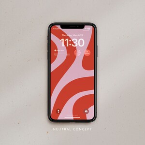 Könnte beinhalten: Ein schwarzes Smartphone mit einem roten und pinkfarbenen abstrakten Design auf dem Bildschirm. Die Uhrzeit ist 11:30 Uhr und das Datum ist Donnerstag, 28. März. Das Telefon hat ein T-Mobile-Logo in der oberen linken Ecke.