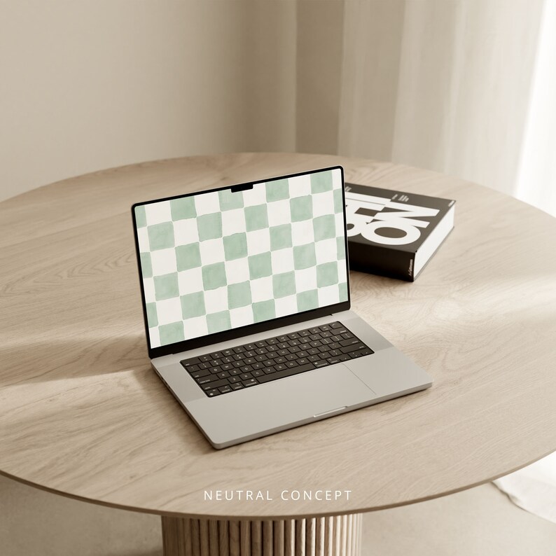 Op de afbeelding: Een zilveren laptop met een groen-wit geruit patroon op het scherm. De laptop is open en staat op een lichtbruine houten tafel. De tekst "NEUTRAL CONCEPT" is op de tafel gedrukt.