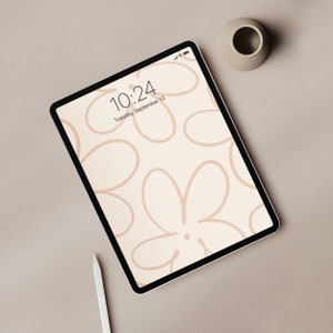 May include: A white tablet with a beige background displaying a digital clock with the time 10:24 and the date Tuesday, September 13. The background of the tablet screen features a pattern of abstract beige flowers.