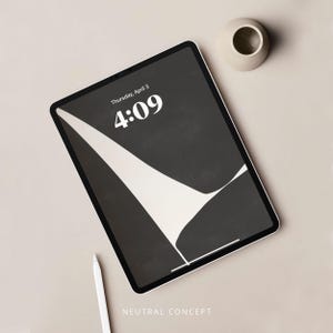May include: A black and white abstract design on a tablet screen with the date "Thursday, April 3" and the time "4:09" displayed. The tablet is on a light beige surface with a small white ceramic bowl.