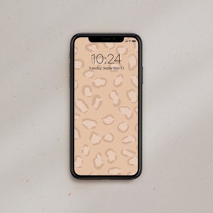 Pode incluir: Um smartphone com uma caixa preta e um papel de parede de leopardo bege. A hora é 10:24 e a data é terça-feira, 13 de setembro.
