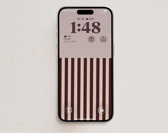 May include: A smartphone displaying a lock screen with a minimalist aesthetic. The top half is a solid light beige, while the bottom half features vertical dark brown stripes. The screen shows the time 1:48, date Fri 15, and weather icons.
