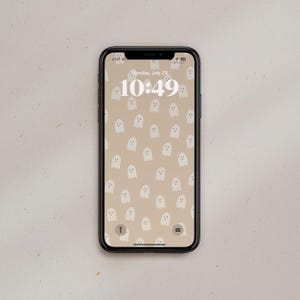 Puede incluir: Un tel&eacute;fono inteligente con una funda negra y un fondo de pantalla con un patr&oacute;n de fantasmas blancos. La hora es 10:49 y la fecha es lunes, 29 de julio.