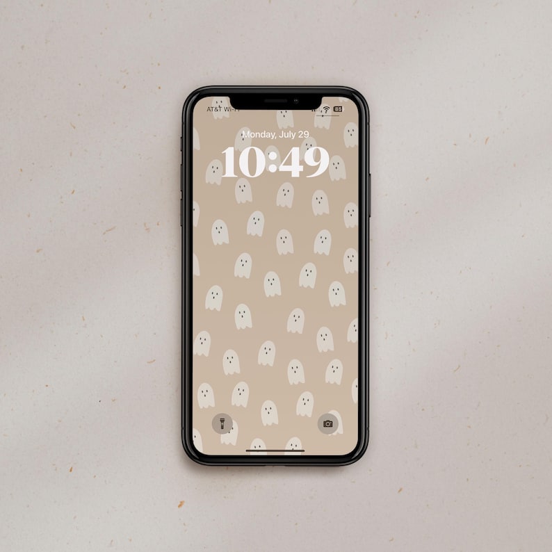 Puede incluir: Un tel&eacute;fono inteligente con una funda negra y un fondo de pantalla con un patr&oacute;n de fantasmas blancos. La hora es 10:49 y la fecha es lunes, 29 de julio.