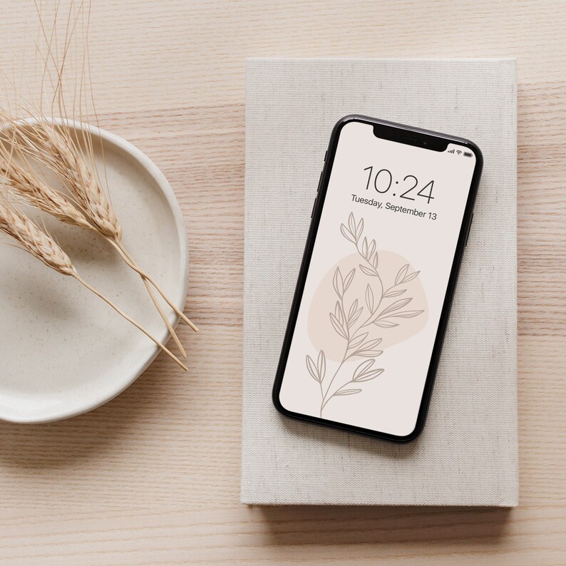 May include: A black smartphone with a white background and a simple line drawing of a branch with leaves. The time is 10:24 and the date is Tuesday, September 13.