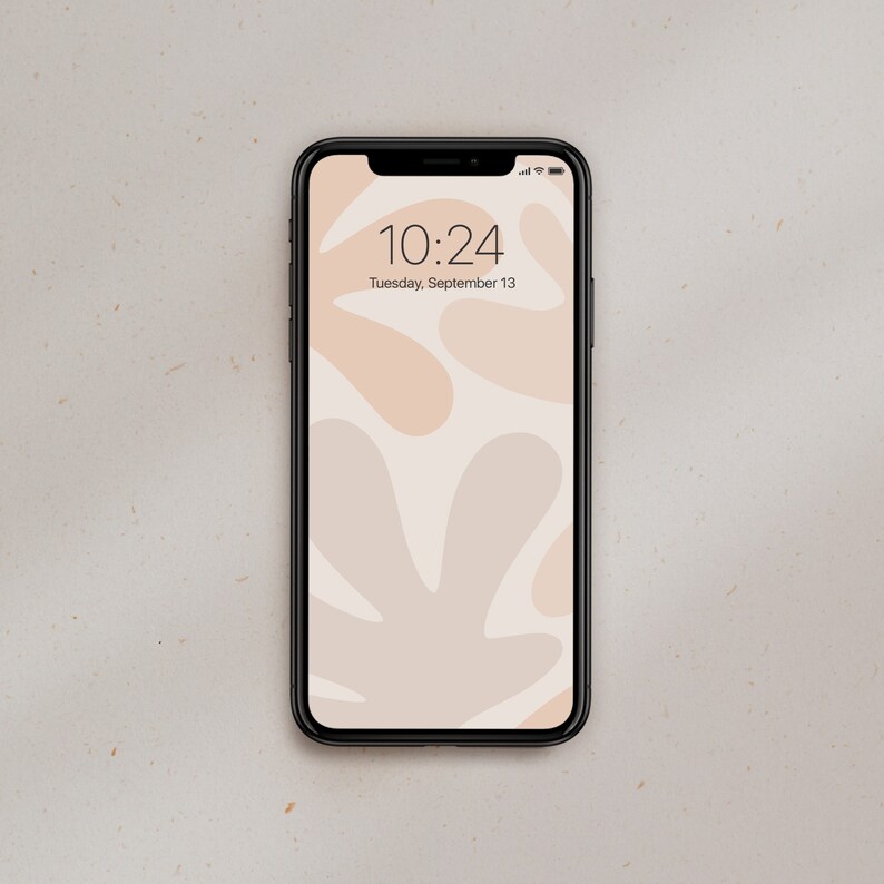 K&ouml;nnte beinhalten: Ein schwarzes Smartphone mit wei&szlig;em Hintergrund und einem abstrakten Muster aus beigefarbenen und hellbraunen Formen. Die Uhrzeit ist 10:24 Uhr und das Datum ist Dienstag, 13. September.
