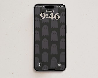 May include: A smartphone displaying a lock screen with a dark gray background featuring a repeating pattern of simple ghost shapes. The screen shows the date Tue Aug 4 and the time 9:46 in a large, light-colored serif font, with icons at the bottom.