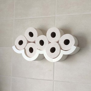May include: White toilet paper holder shaped like a cloud with six rolls of toilet paper.