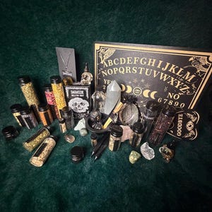 Peut inclure: Une collection d'objets occultes, dont une planche Ouija, des bocaux en verre remplis d'herbes, des cristaux et d'autres outils rituels, disposés sur une surface vert foncé. L'ensemble crée une esthétique mystique.