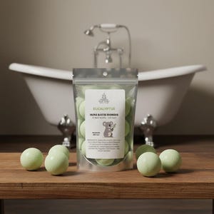 May include: A clear bag of eucalyptus mini bath bombs with a koala bear graphic. The bag is in front of a white clawfoot bathtub. Several green bath bombs are scattered on a wooden surface.