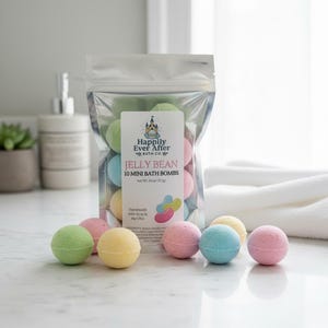 May include: A clear bag of colorful bath bombs labeled "Jelly Bean" with the text "Happily Ever After Bath Co." The bag contains 10 mini bath bombs in various pastel colors. Several bath bombs are arranged in front of the bag.