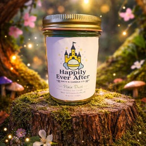 May include: A glass jar candle with a gold lid, labeled "Happily Ever After" and "Pixie Dust." The candle sits on a moss-covered tree stump, surrounded by flowers and a whimsical forest backdrop. The candle weighs 6 oz.