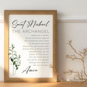 May include: A printable wall art print with a white background and black text. The text reads "Saint Michael The Archangel" and includes a prayer to Saint Michael. The print features a green leafy branch on the left side.