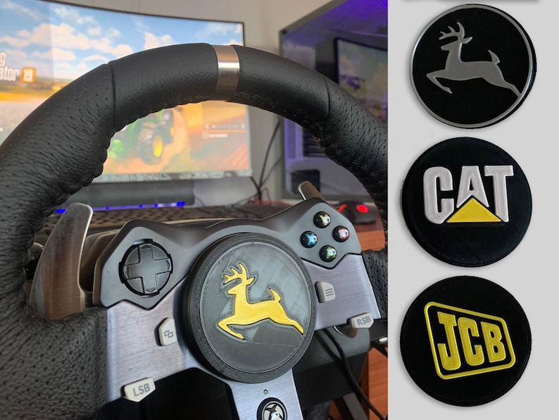 Puede incluir: Un volante de carreras negro con un borde plateado y un logotipo de ciervo amarillo y negro en el bot&oacute;n central. El volante est&aacute; conectado a una consola de juegos con botones y una palanca de mando. El fondo muestra una pantalla de ordenador con un videojuego.
