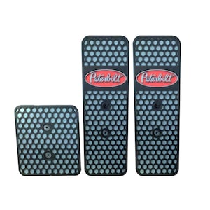 Pode incluir: Três capas de pedal pretas com um padrão de favo de mel e o logotipo Peterbilt em vermelho e prata.