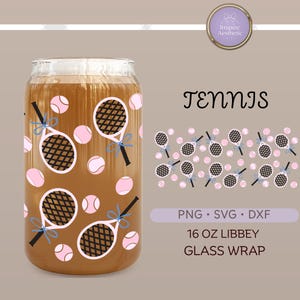 May include: A clear 16 oz Libbey glass wrap featuring a tennis theme. The design includes pink tennis balls and tennis rackets with black handles and white frames. The word "Tennis" is written in a decorative font.