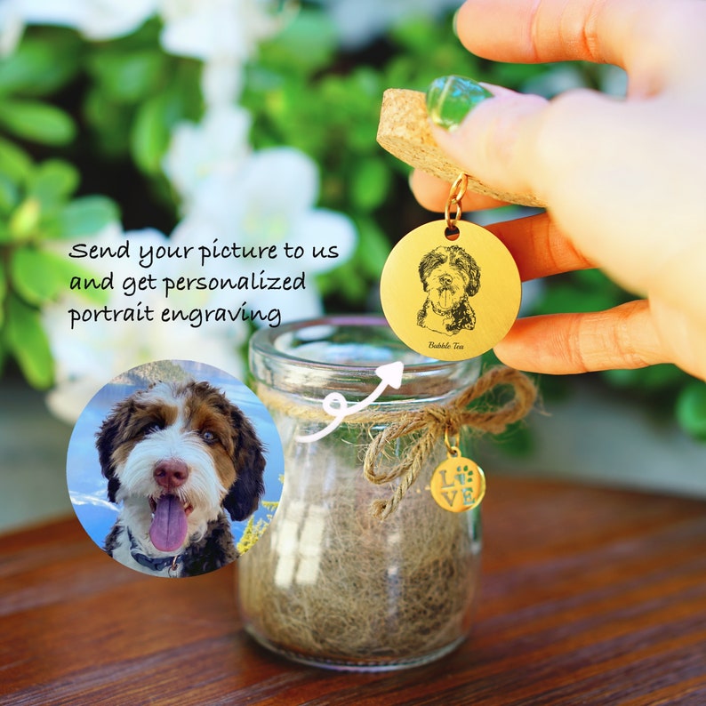 May include: A gold-colored metal charm with a personalized engraved portrait of a dog. The charm is attached to a cork stopper and a small glass jar with a brown twine bow. The text "Bubble Tea" is engraved on the charm.
