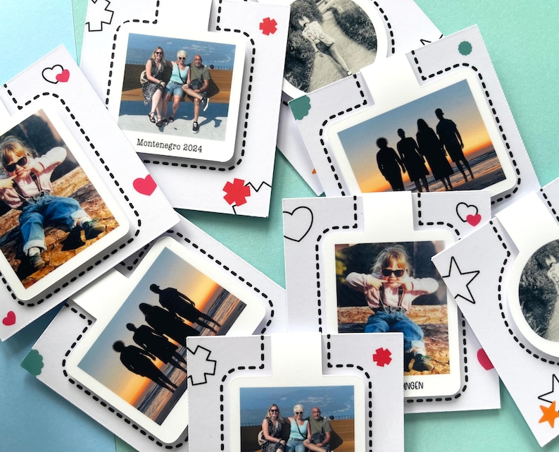 Viele magnetische Lesezeichen mit personalisierten Fotomotiven, befestigt an einer Backing-Card, liegen übereinnader verteilt auf einem farbigen Untergrund.