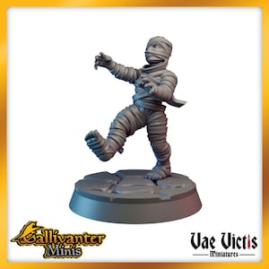 May include: A gray painted miniature of a mummy, standing on a gray base. The mummy is wrapped in bandages and has a cloth covering its head. The mummy is walking with its left leg forward.