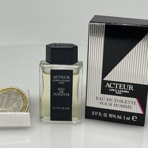 May include: A clear glass bottle of men's cologne with a black cap and label. The label reads "Acteur Loris Azzaro Paris Eau de Toilette 0.17 fl. oz. 5 ml".