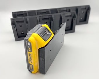 May include: A black wall mount with a yellow and black DeWalt 18V XR 20Ah battery attached. The mount has several holes for attaching to a wall.