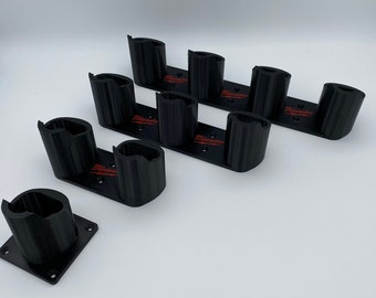 May include: Black plastic wall mount with six slots for holding tools. The slots are labelled "Milwaukee" in red lettering.