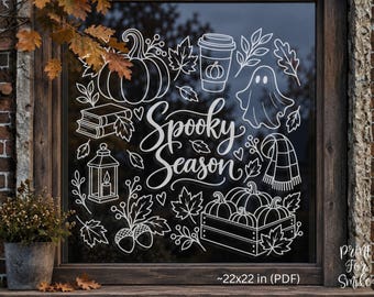 May include: A white vinyl window decal featuring the text Spooky Season surrounded by line art illustrations of pumpkins, a coffee cup, a ghost, books, a lantern, a scarf, acorns, and autumn leaves, with a visible dimension of 22x22 inches.