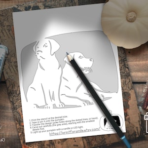 May include: A black and white stencil featuring two Labrador Retrievers, with dotted lines for carving. A pencil rests on the stencil. Instructions are printed below the image, including a website address for the product.